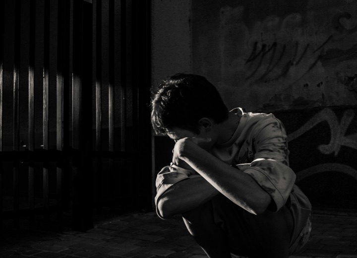Person seated alone in a dark room